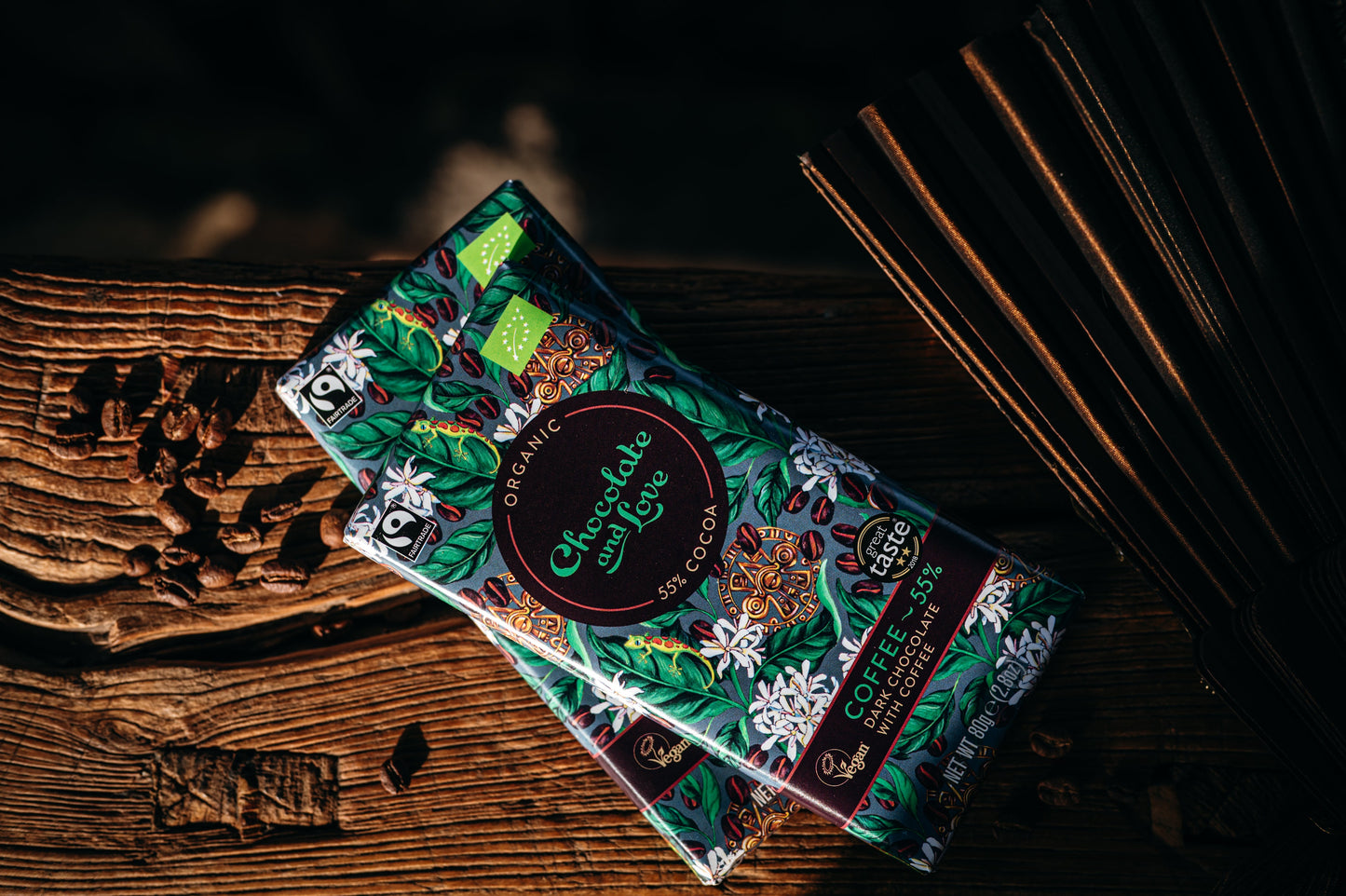 Two coffee chocolate bars with decorative packaging on a wooden surface