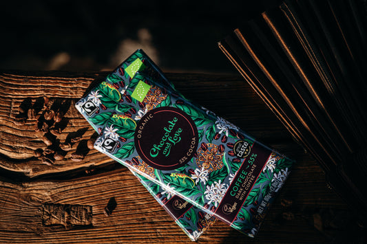 Two coffee chocolate bars with decorative packaging on a wooden surface