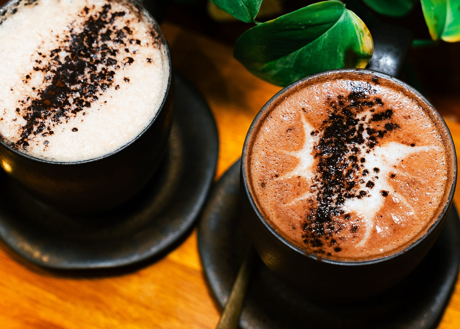 Two cups of hot chocolate with whipped cream and chocolate shavings on a wooden board with 'Chocolate and Love' text.